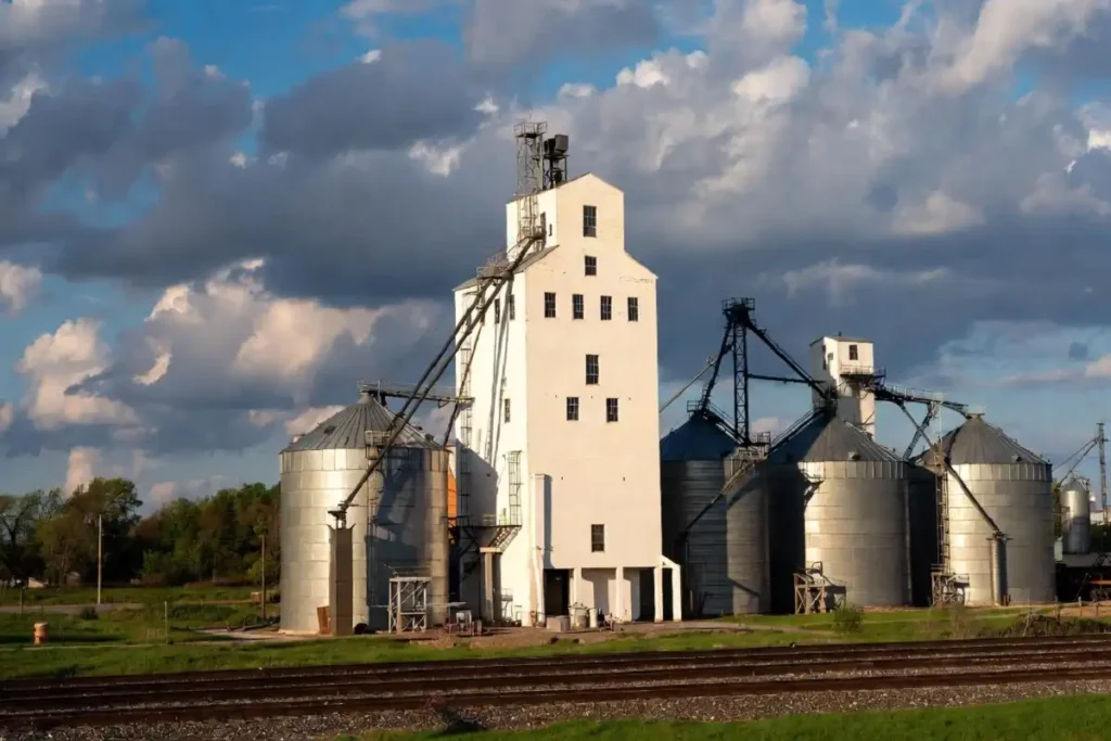 Tall grain elevator and storage bins at a rural Midwest cooperative in spring 2026