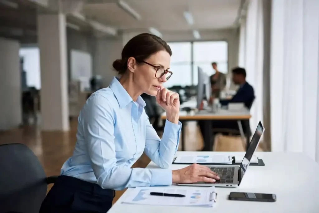 A middle manager reviewing reports in a modern office during a corporate transition