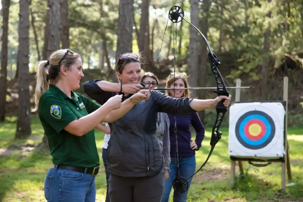 Instructor coaching a beginner archer at the Ohio Women's Outdoor Adventure weekend at Salt Fork State Park